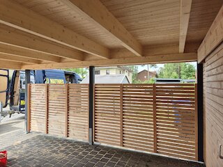 Innenansicht eines Doppelcarports mit Holzdach und seitlichen Holzlamellen