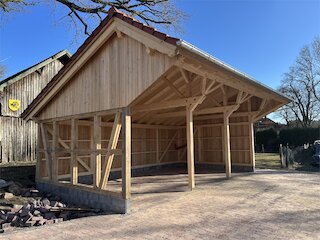 Freistehender Holzcarport mit Satteldach und sichtbarer Fachwerkkonstruktion
