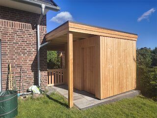 Kleiner Carport mit Flachdach und geschlossenem Geräteraum aus senkrechter Holzschalung