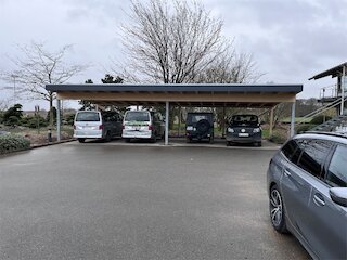 Reihencarport mit Flachdach für mehrere Fahrzeuge auf einem Firmenparkplatz