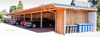 Breiter Reihencarport aus Holz mit Satteldach und Stellplätzen für mehrere Fahrzeuge