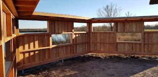 Holzterrasse am Wohnhaus mit Geländer, Sichtschutz und überdachtem Sitzbereich