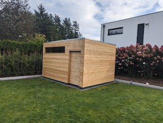 Modernes kubisches Gartenhaus mit senkrechten Holzlamellen und Flachdach