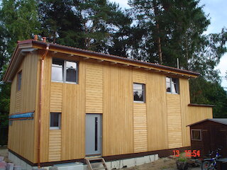 Zweigeschossiger Holzanbau mit heller Holzfassade