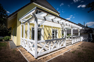 Weiße Pergola aus Holz mit dekorativem Terrassengeländer